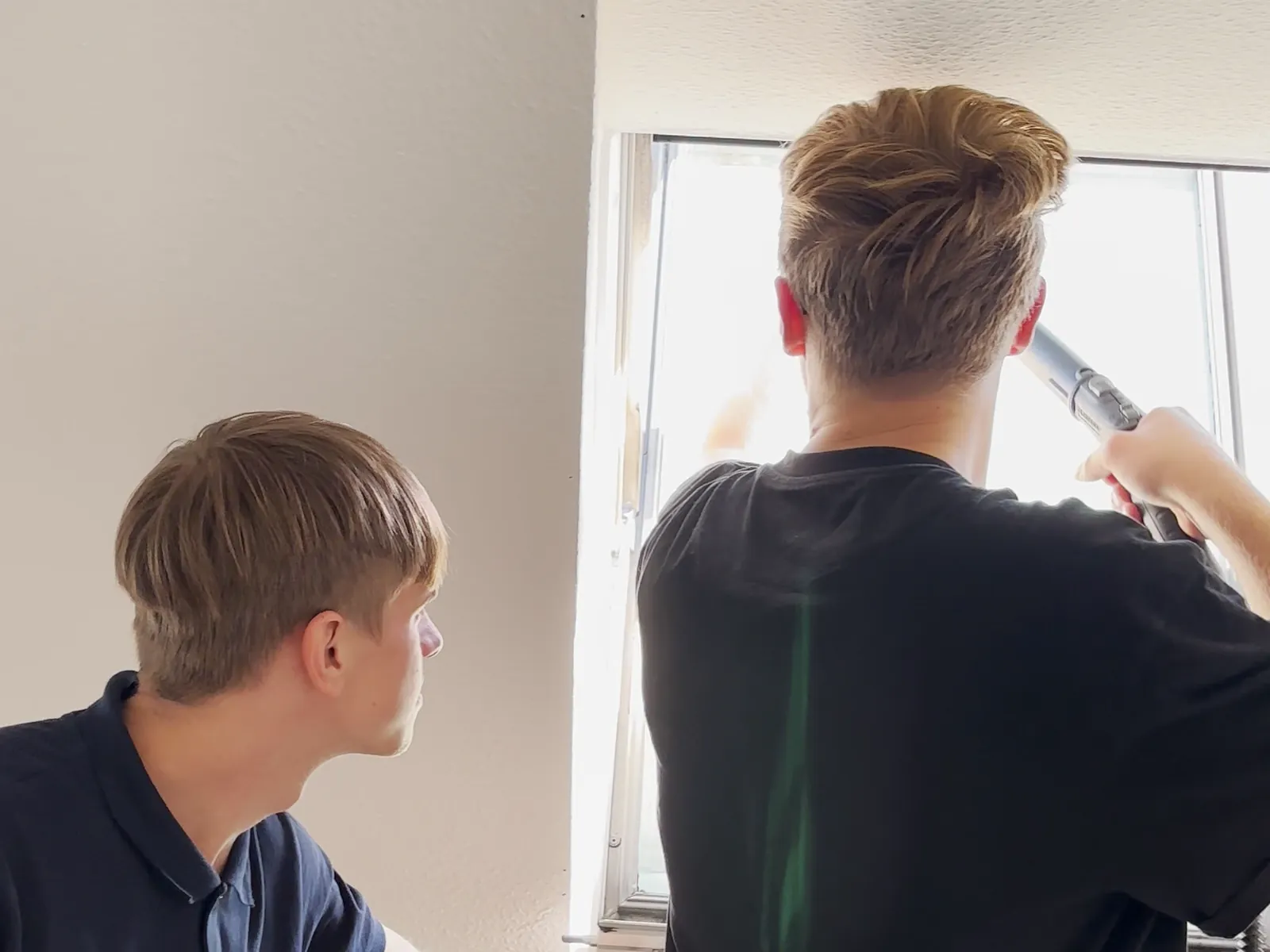 Zwei GE+ES-Mitarbeiter reinigen gemeinsam ein Dachfenster