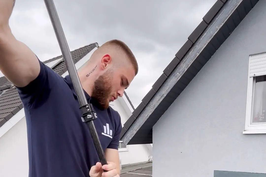Glasreinigung mit der Teleskopstange auf dem Dach eines Wintergartens